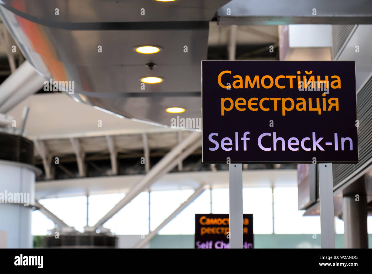 Pointer with an inscription in the Ukrainian - Self check-in at the airport. Information stand, self registration panel Stock Photo