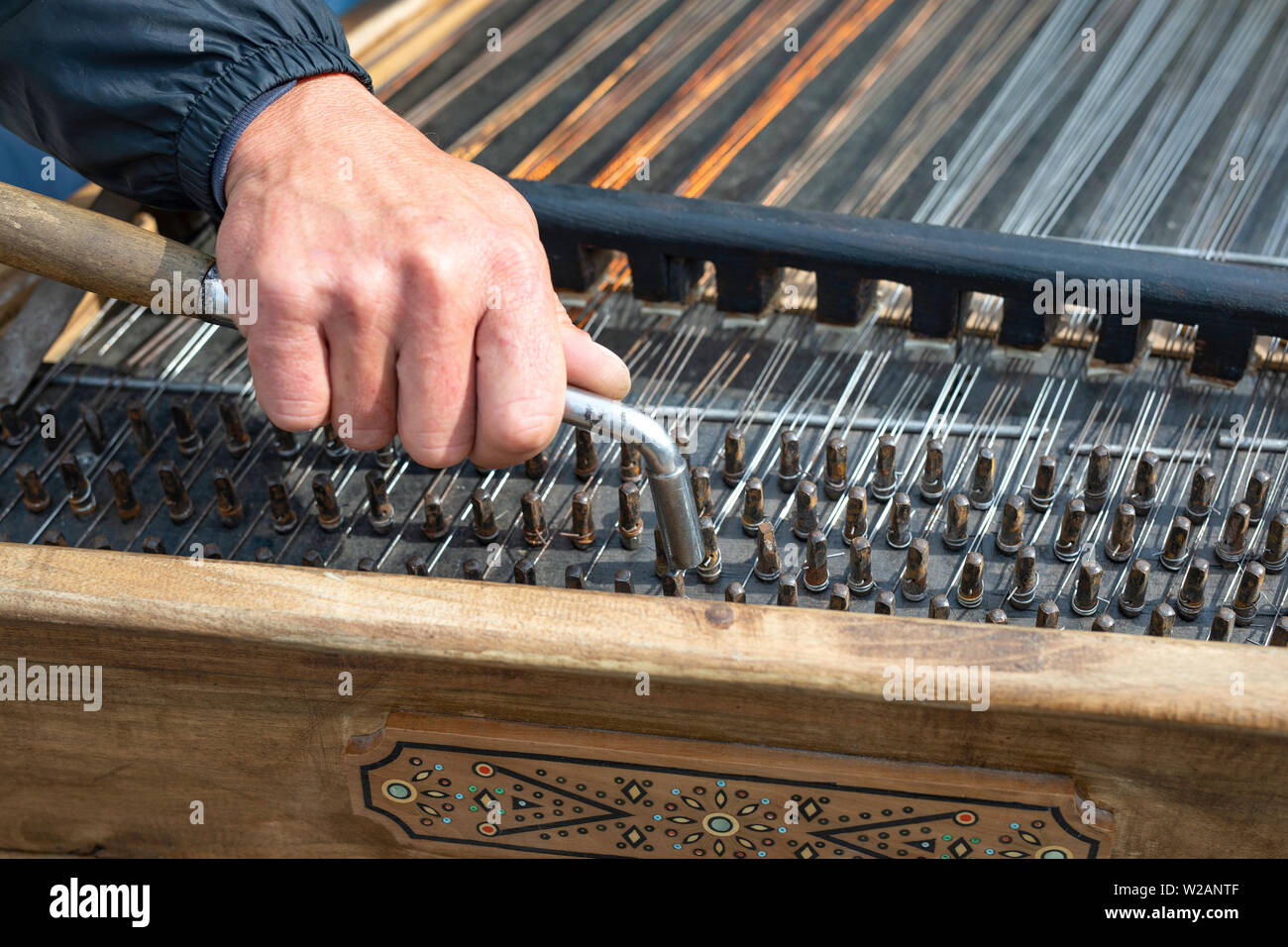 Tuning an old instrument, dulcimer Stock Photo Alamy