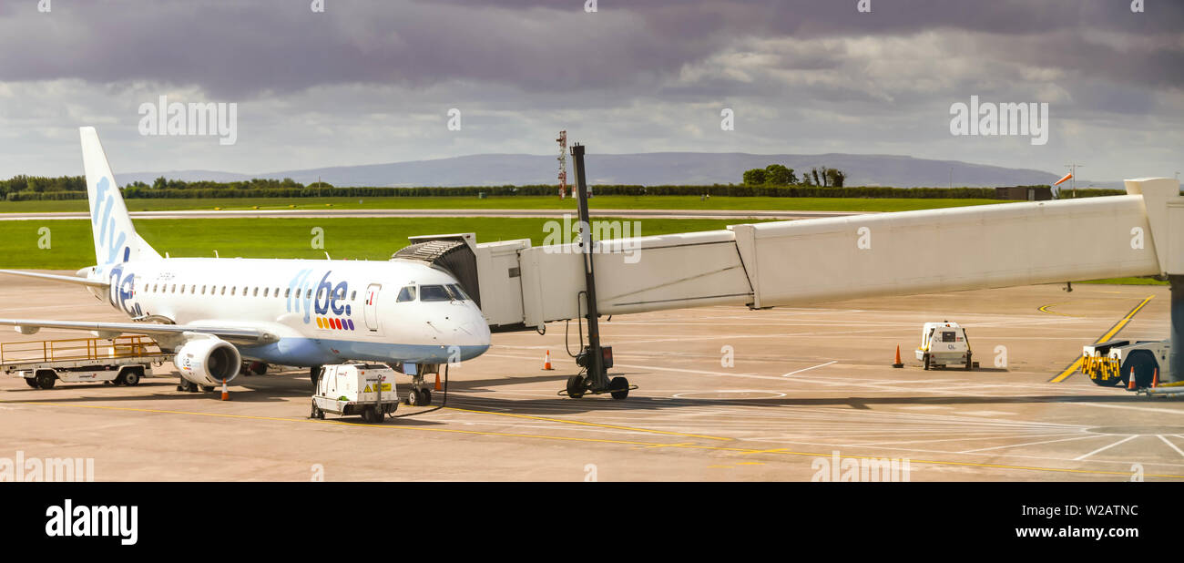 CARDIFF WALES AIRPORT - JUNE 2019: Flybe Embraer E175 plane attached to a jet bridge  at Cardiff Wales Airport. Stock Photo