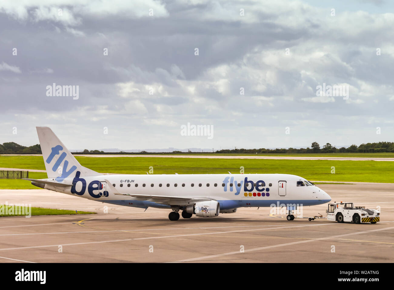 CARDIFF WALES AIRPORT - JUNE 2019: Flybe Embraer E175 plane being pushed by an airport tug for departure from Cardiff Wales Airport. Stock Photo