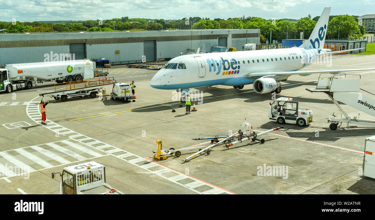 CARDIFF WALES AIRPORT - JUNE 2019:  Embraer E175 jet operated by Flybe being marshalled to its stand at Cardiff Wales Airport. Stock Photo