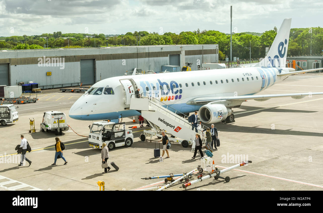 CARDIFF WALES AIRPORT - JUNE 2019: Passengers disembarking an Embraer E175 jet operated by Flybe at Cardiff. Stock Photo