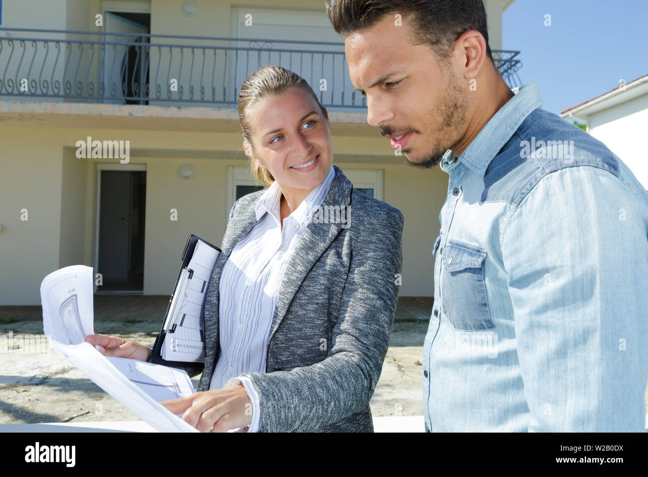 colleagues with house plans outdoors Stock Photo Alamy