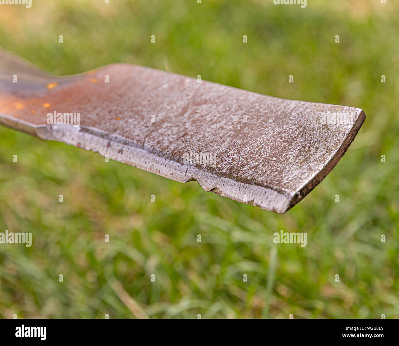 Lawn mower blade that is rusty, damaged, and dull and needing sharpened Stock Photo