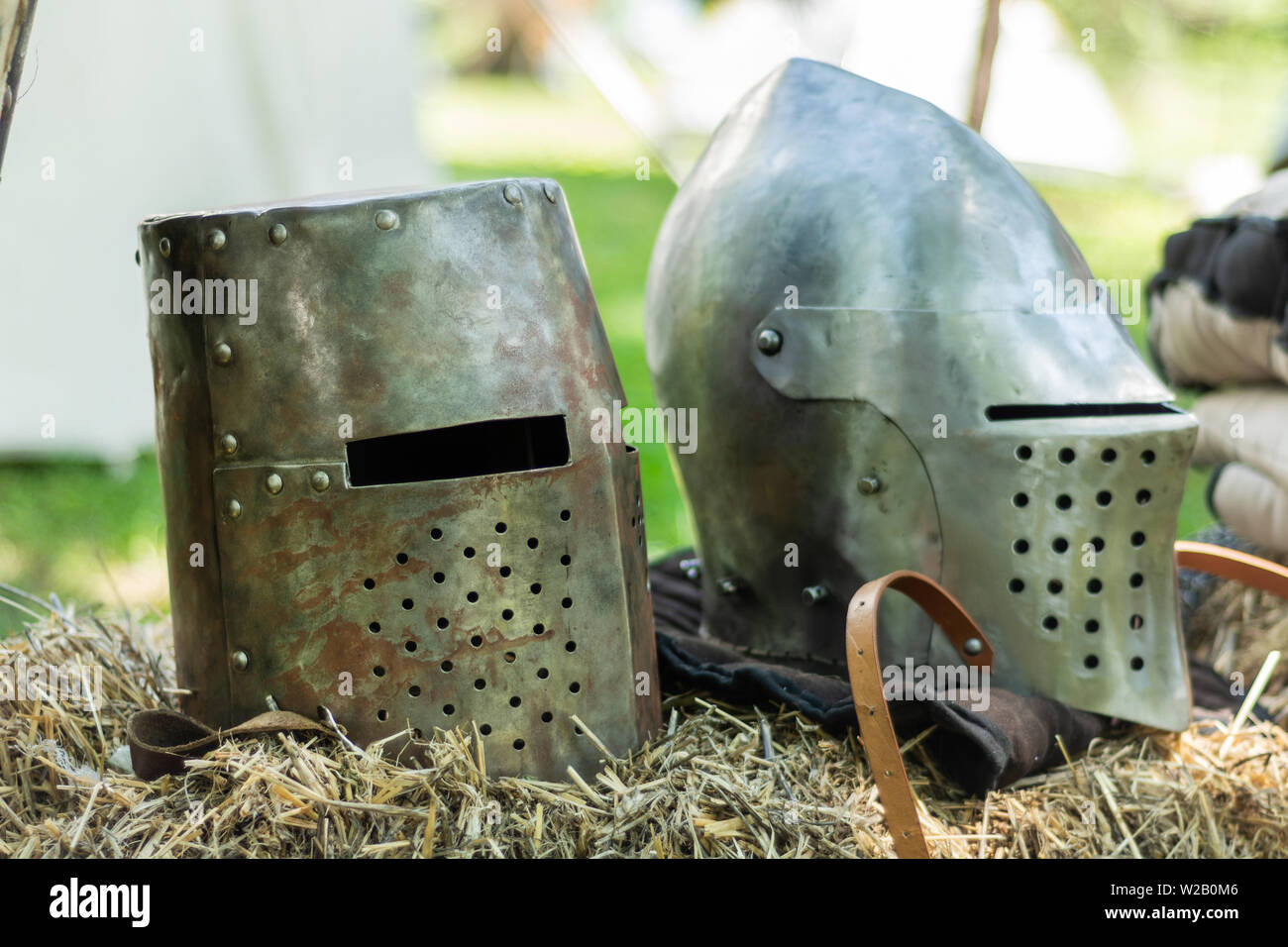Knightly medieval metal two helmets on the stand. Old dark ages armor