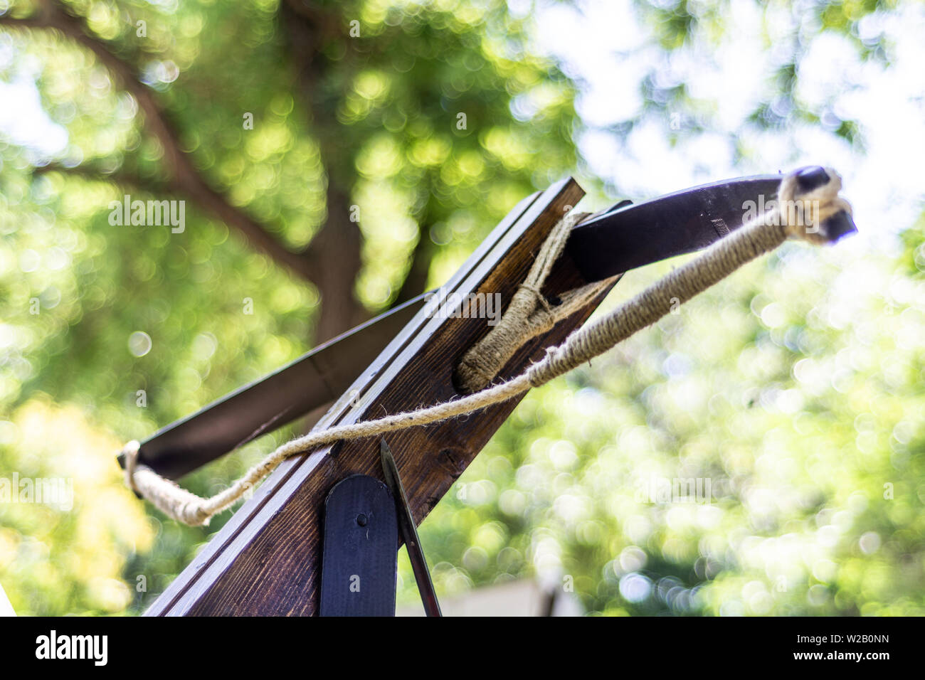 Medieval old big crossbow without an arrow in nature and blurred green background. Medieval war equipment concept. Close up, selective focus Stock Photo