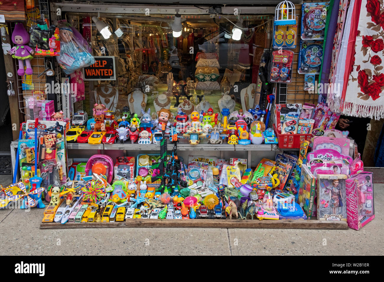 A very crowded display of inexpensive children's toys for sale outside a sari shop on 74th Street in Jackson Heights, Queens, New York City. Stock Photo