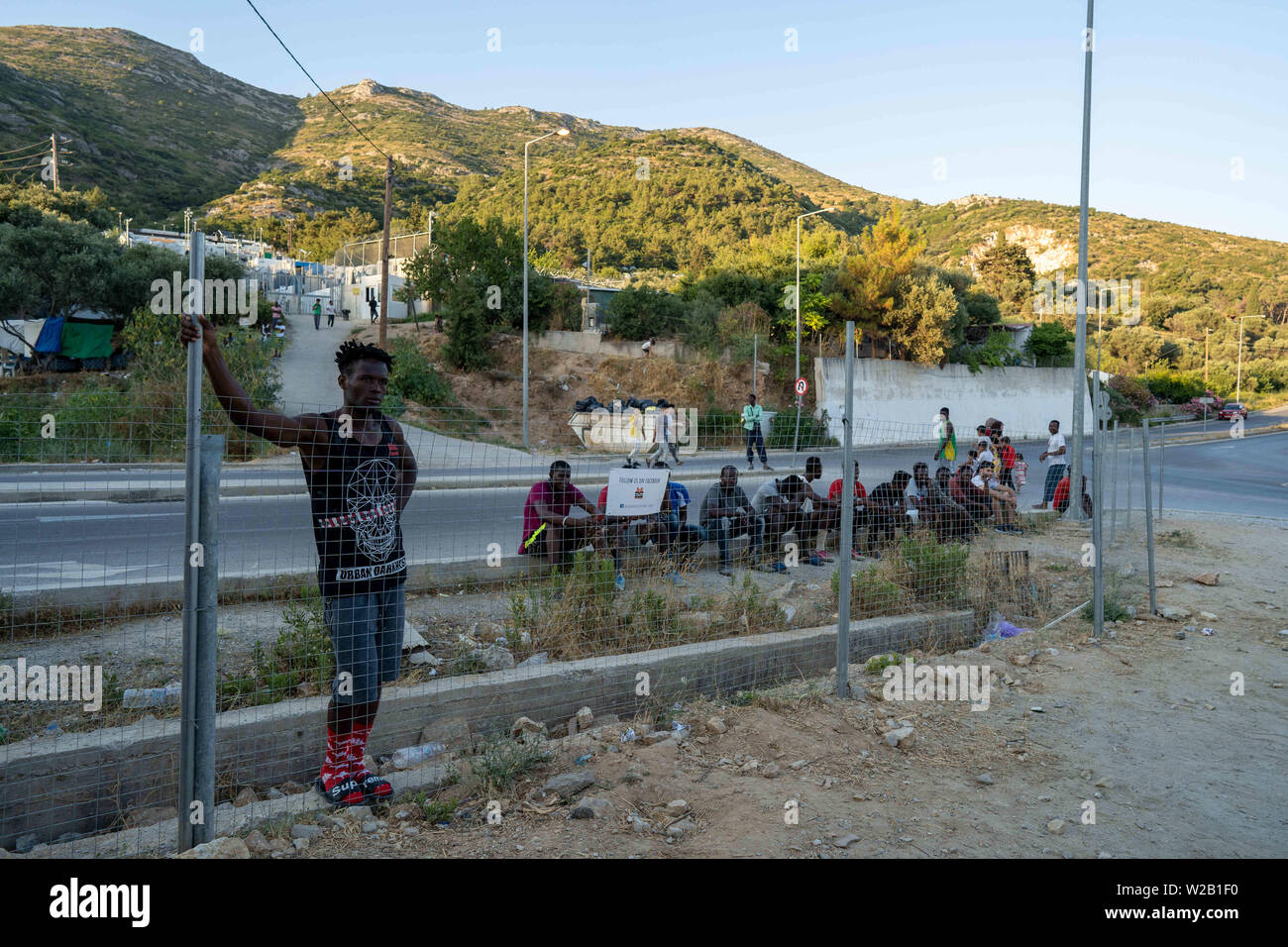 Samos, Samos, Greece. 28th June, 2019. A group of migrants living in or around the migrant camp on Samos gather to watch a game of football between players from Cameroon and the Democratic Republic of Congo. Samos Island is one of Europe's migrant hotspots acting as a reception and identification centre (RIC). It was established as a temporary accommodation site where migrants could be processed before moving to a refugee camp on the mainland. However, due to the continued number of arrivals, the mainland camps are full and so migrants are being left at the islands. The conditions are inhu Stock Photo