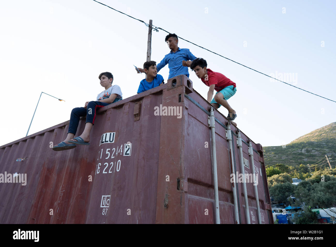 Samos, Samos, Greece. 28th June, 2019. Kids play on top of a container on Samos.Samos Island is one of Europe's migrant hotspots acting as a reception and identification centre (RIC). It was established as a temporary accommodation site where migrants could be processed before moving to a refugee camp on the mainland. However, due to the continued number of arrivals, the mainland camps are full and so migrants are being left at the islands. The conditions are inhuman as the Central Government has for several years ignored requests from the municipality for assistance for the island. (Credi Stock Photo