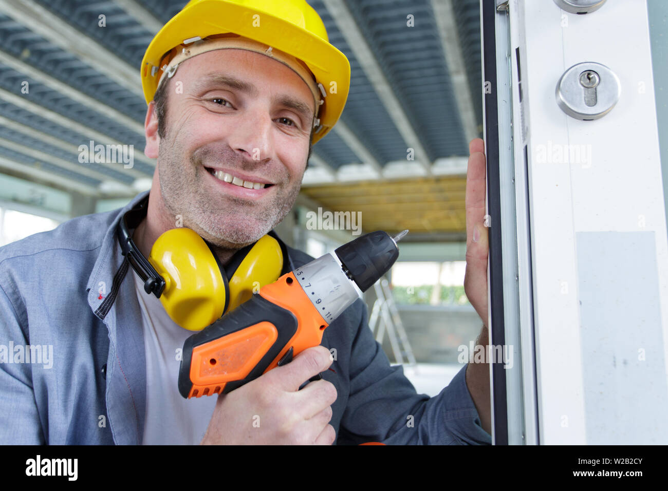 happy man drilling the wall with drill perforator Stock Photo - Alamy