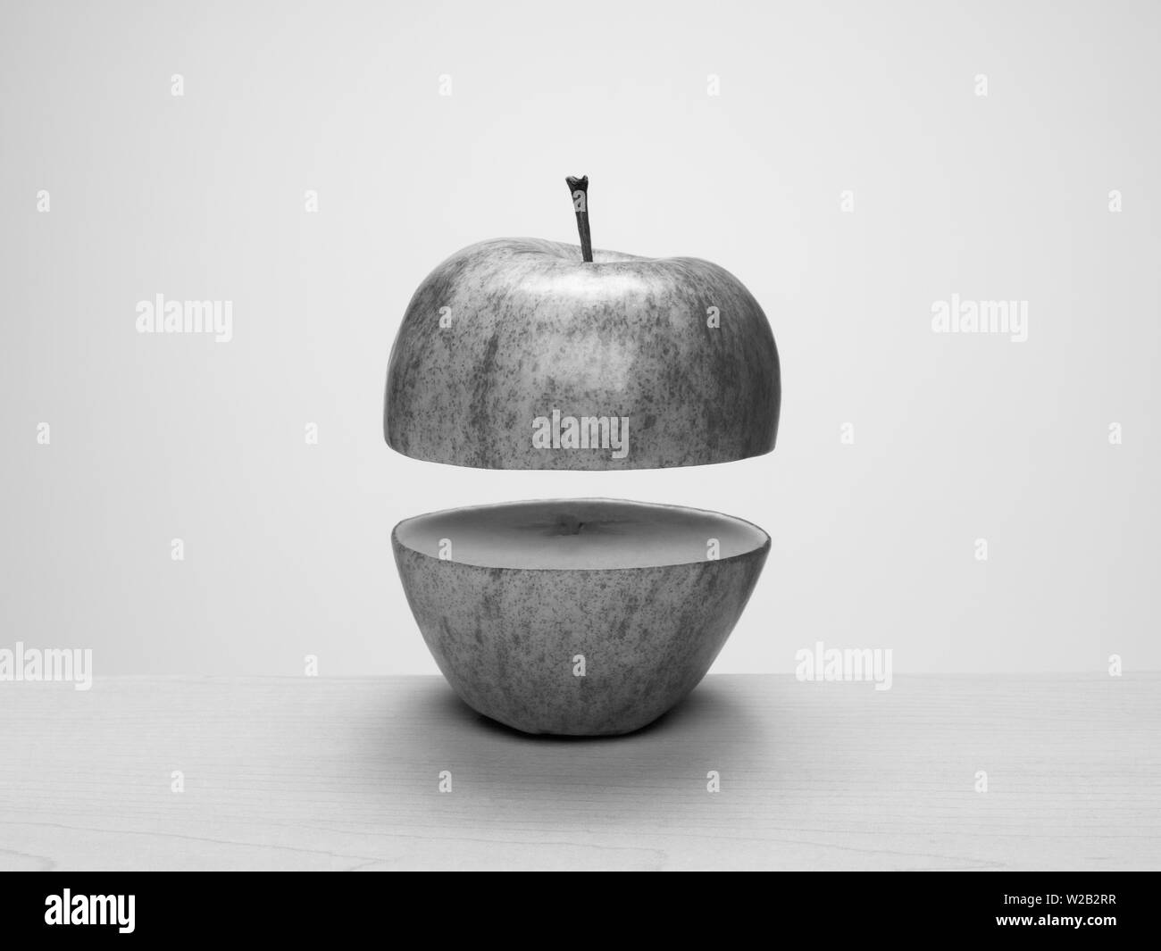 Black and white apple cut in half, separated and floating apart. Concept: parts, apart, float, levitate, separation Stock Photo