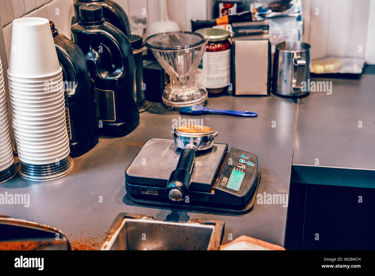 Portafilter with ground black coffee lying on professional scale. Interior  of small business restaurant local cafe cafeteria. Process of making hot dr  Stock Photo - Alamy