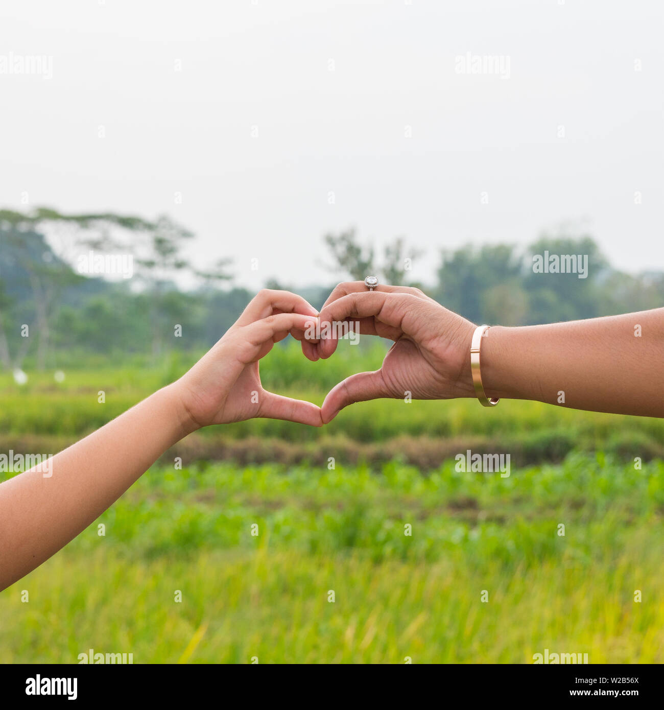 A mother and her young son making love heart shape with hands whilst  walking through countryside close up hands only square image with copy  space for Stock Photo - Alamy