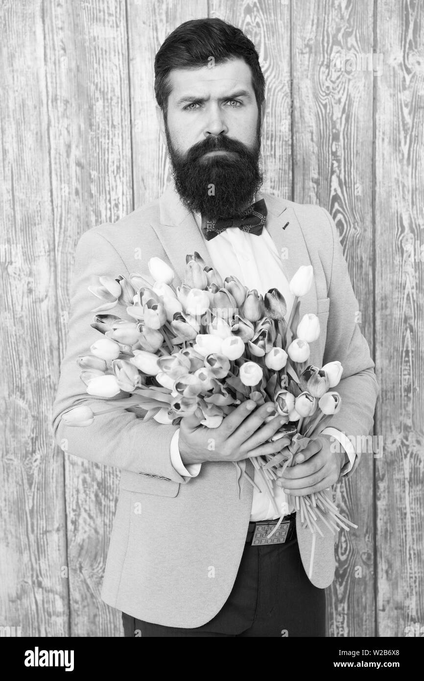 To say I love you. Womens day. Flower for March 8. Spring gift. Bearded man hipster with flowers. Bearded man with tulip bouquet. Love date. international holiday. Love spring. Show your love. Stock Photo