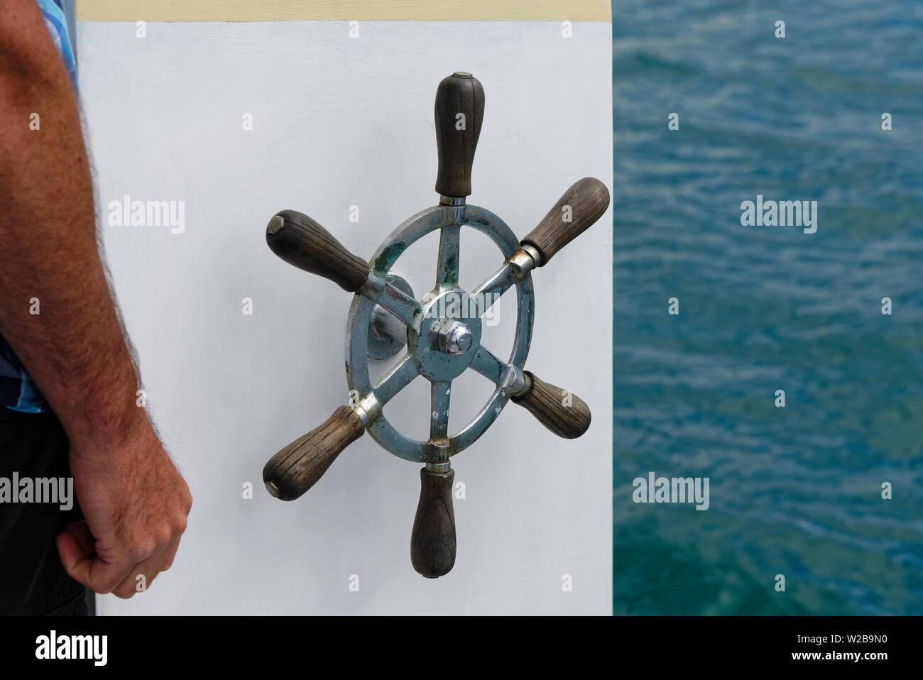 The helm, a ships steering wheel against the white of the ship Stock