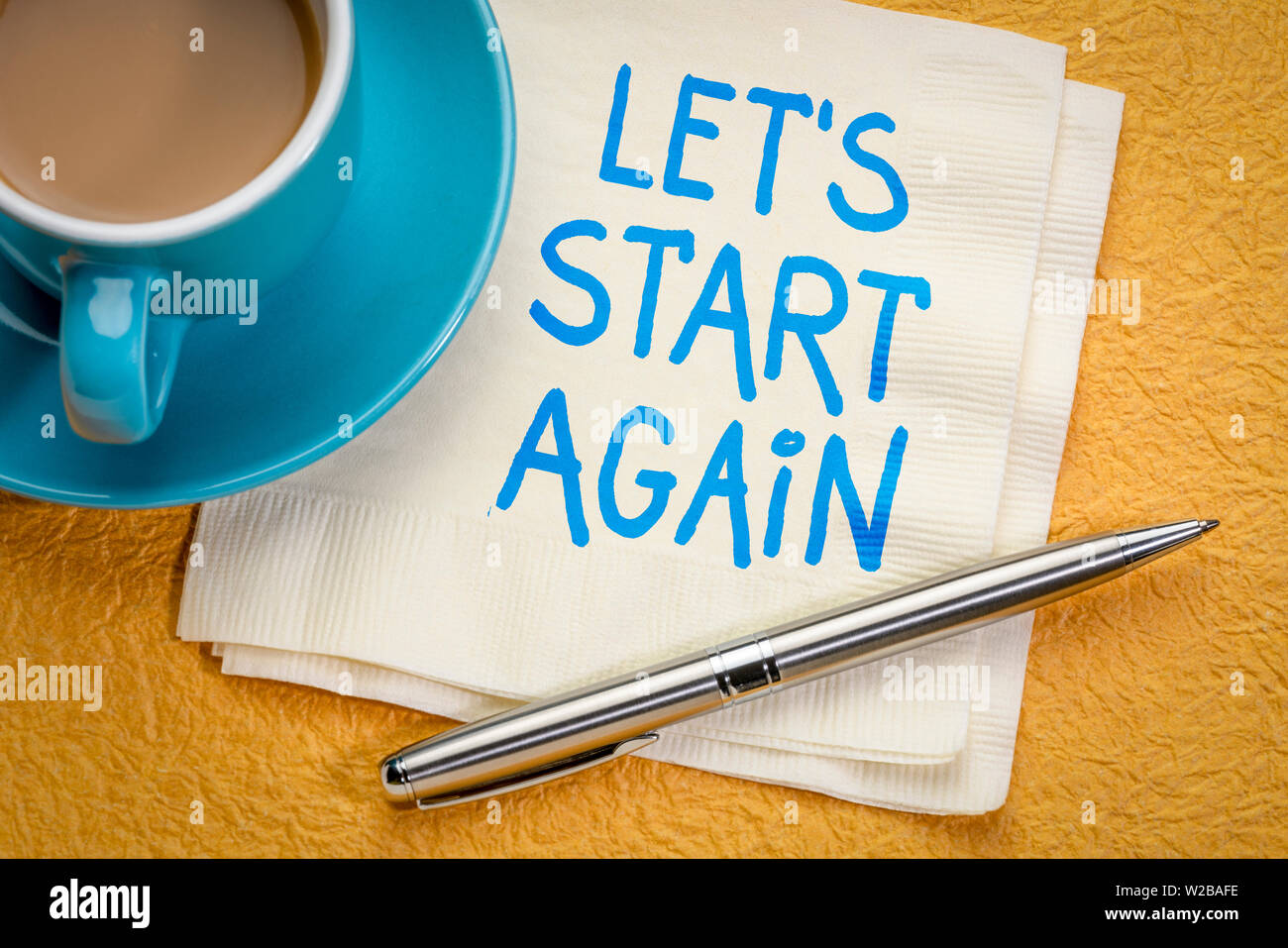 Let's start again note - motivational handwriting on a napkin with a cup of coffee Stock Photo