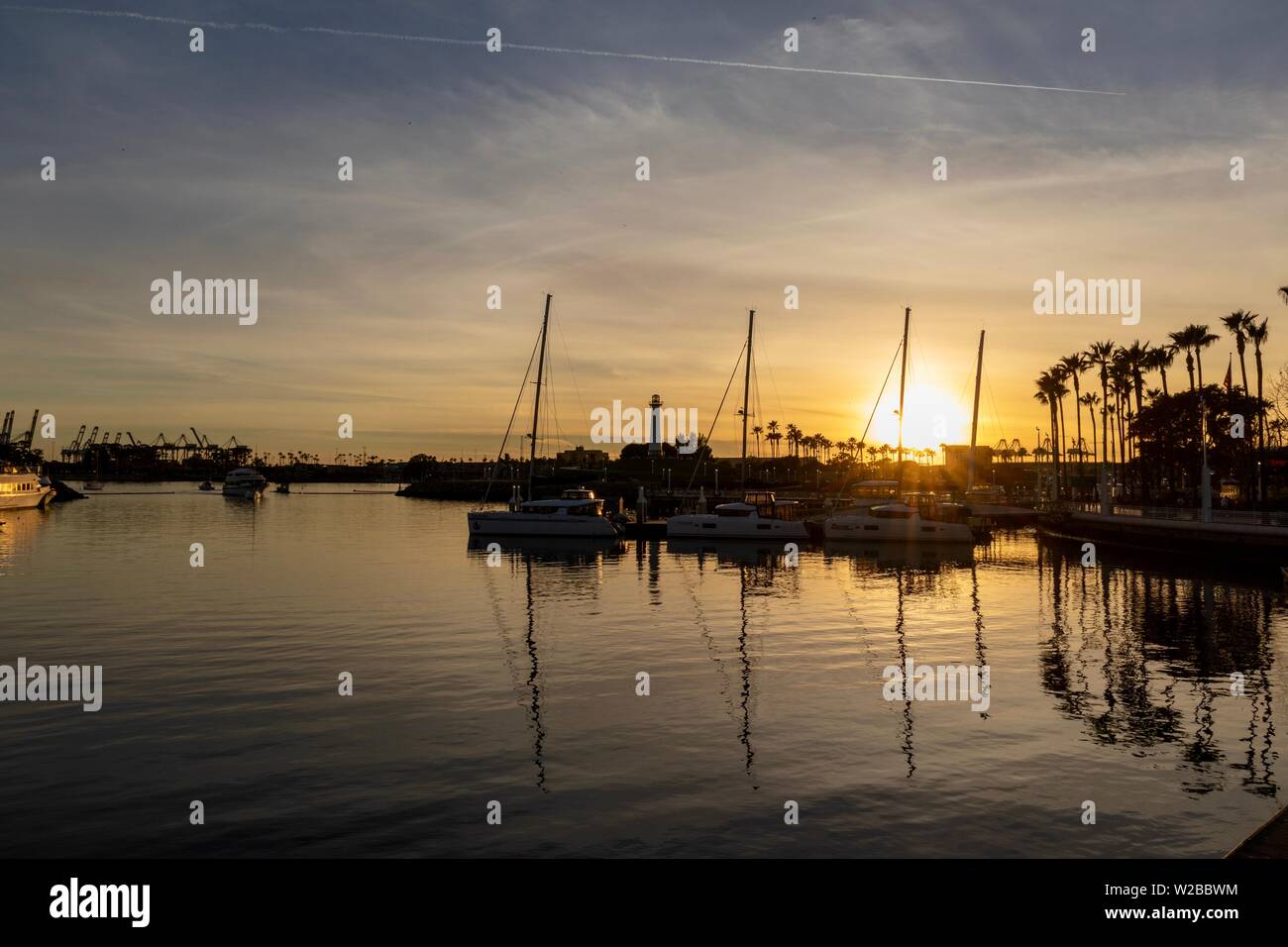 Boats moored in a harbor during sunset Stock Photo