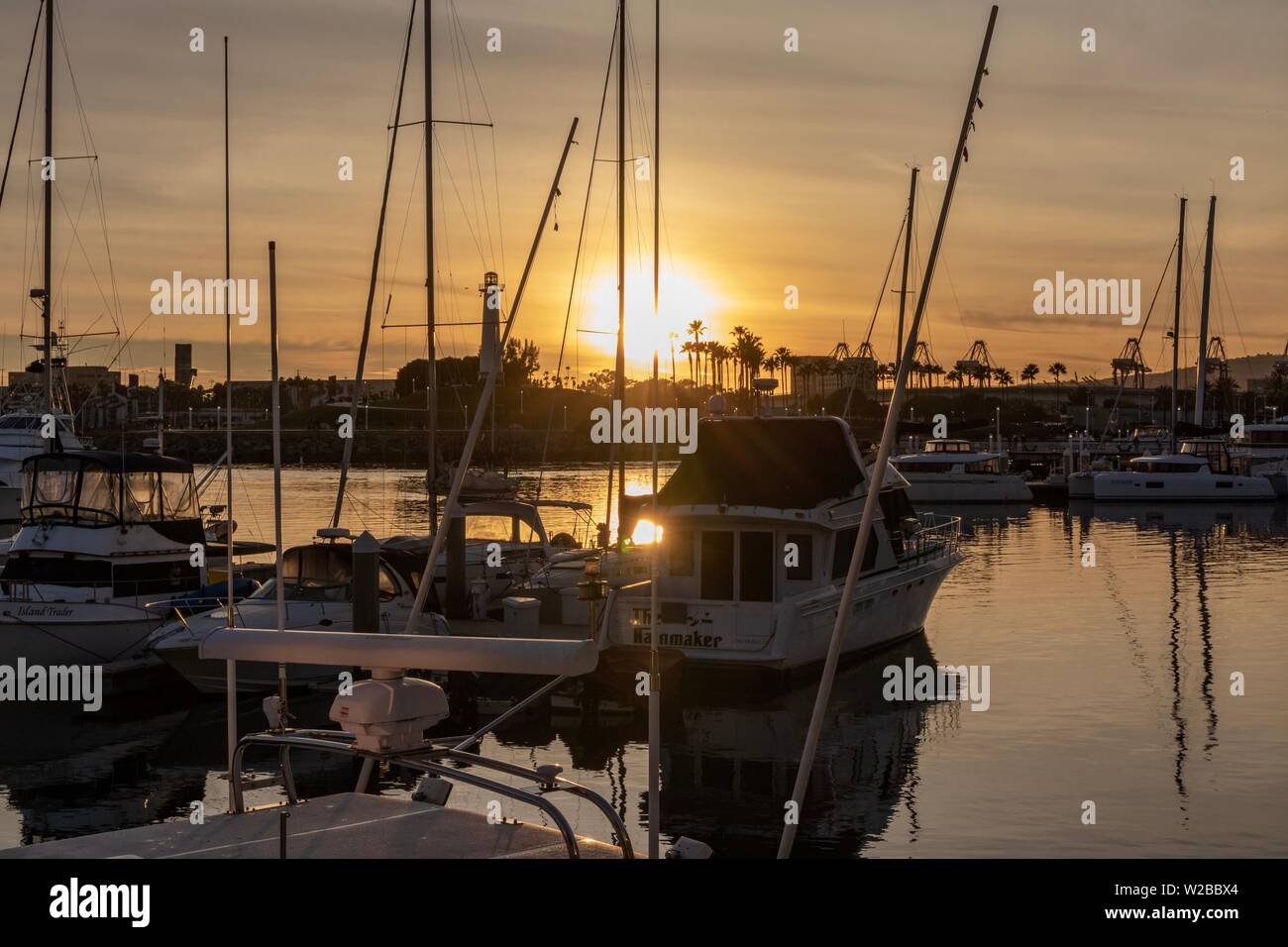 Boats moored in a harbor during sunset Stock Photo