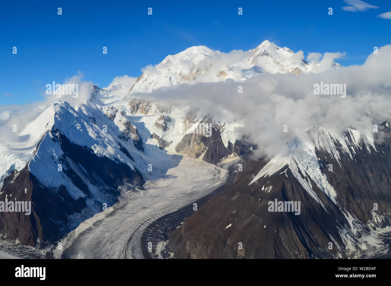 Aerial view of Mount Denali - mt Mckinley peak from a plane with glaciers around and blue sky above. Denali National Park Stock Photo