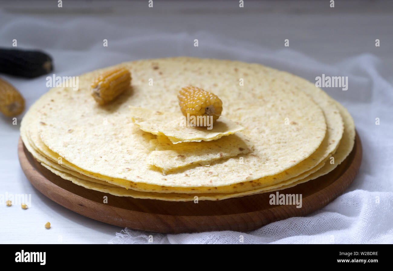 https://c8.alamy.com/comp/W2BDRE/a-stack-of-round-corn-tortillas-on-a-wooden-board-and-corncobs-selective-focus-W2BDRE.jpg