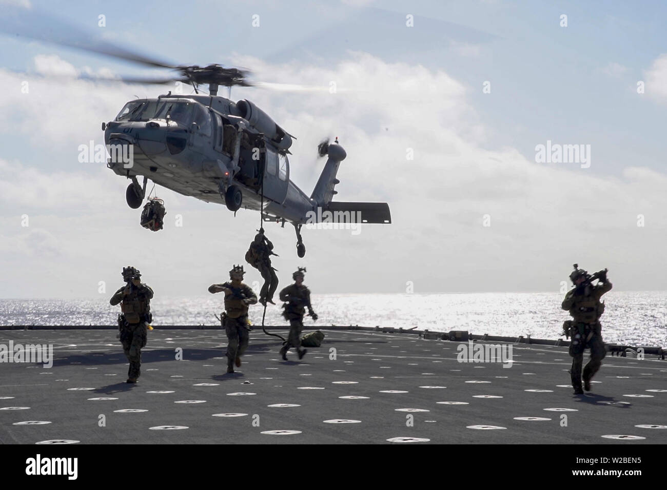 Force Reconnaissance Marines with Maritime Raid Force, 31st Marine Expeditionary Unit, fast rope from an MH-60S Sea Hawk during a visit, board, search and seizure exercise aboard the amphibious dock landing ship USS Ashland (LSD 48), underway in the Coral Sea, June 29, 2019. Ashland, part of the Wasp Amphibious Ready Group, with embarked 31st MEU, is operating in the Indo-Pacific region to enhance interoperability with partners and serve as a ready-response force for any type of contingency, while simultaneously providing a flexible and lethal crisis response force ready to perform a wide rang Stock Photo