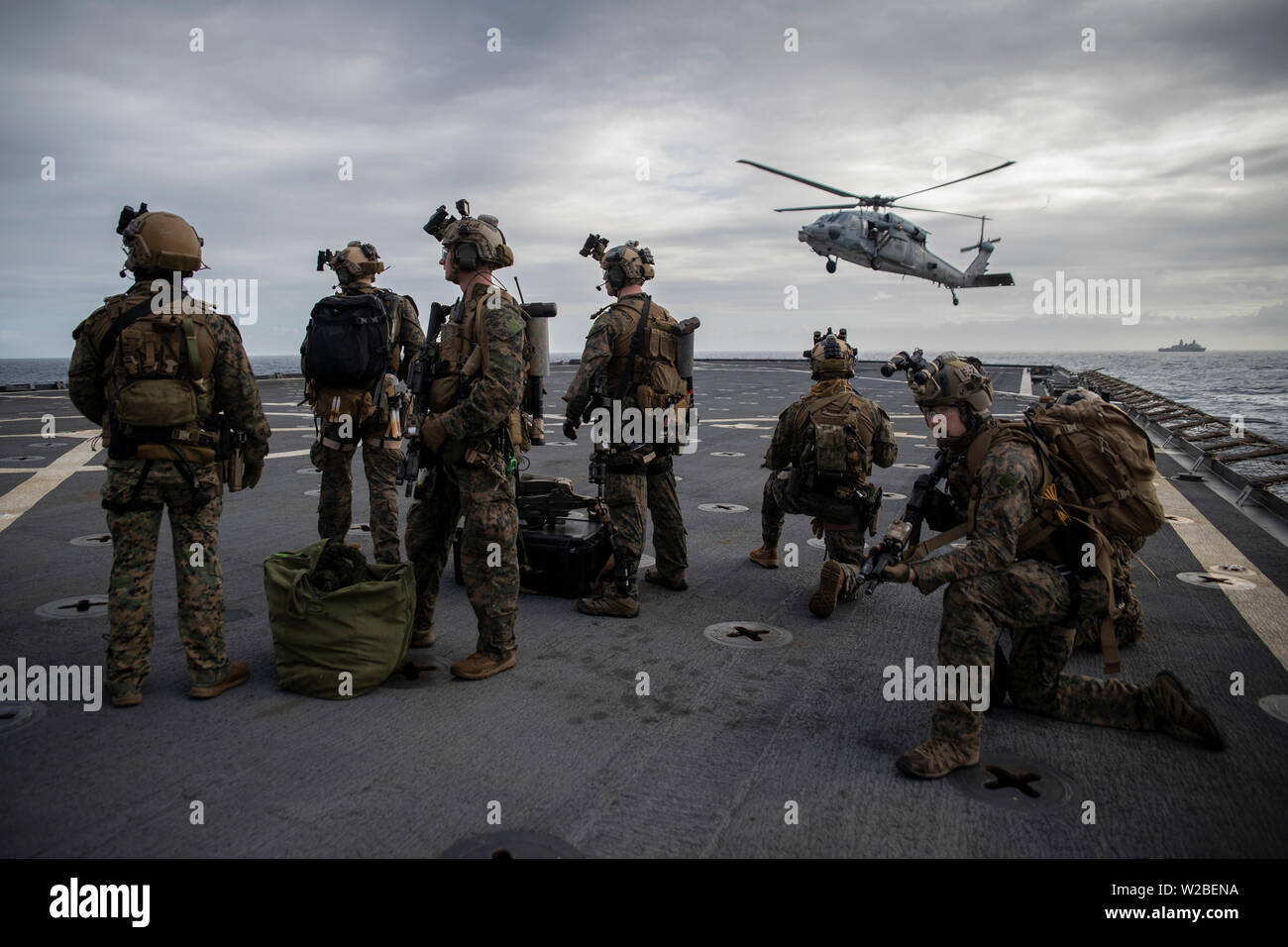 Force Reconnaissance Marines with Maritime Raid Force, 31st Marine Expeditionary Unit, provide security before boarding an MH-60S Sea Hawk during a visit, board, search and seizure exercise aboard the amphibious dock landing ship USS Ashland (LSD 48), underway in the Coral Sea, June 29, 2019. Ashland, part of the Wasp Amphibious Ready Group, with embarked 31st MEU, is operating in the Indo-Pacific region to enhance interoperability with partners and serve as a ready-response force for any type of contingency, while simultaneously providing a flexible and lethal crisis response force ready to p Stock Photo