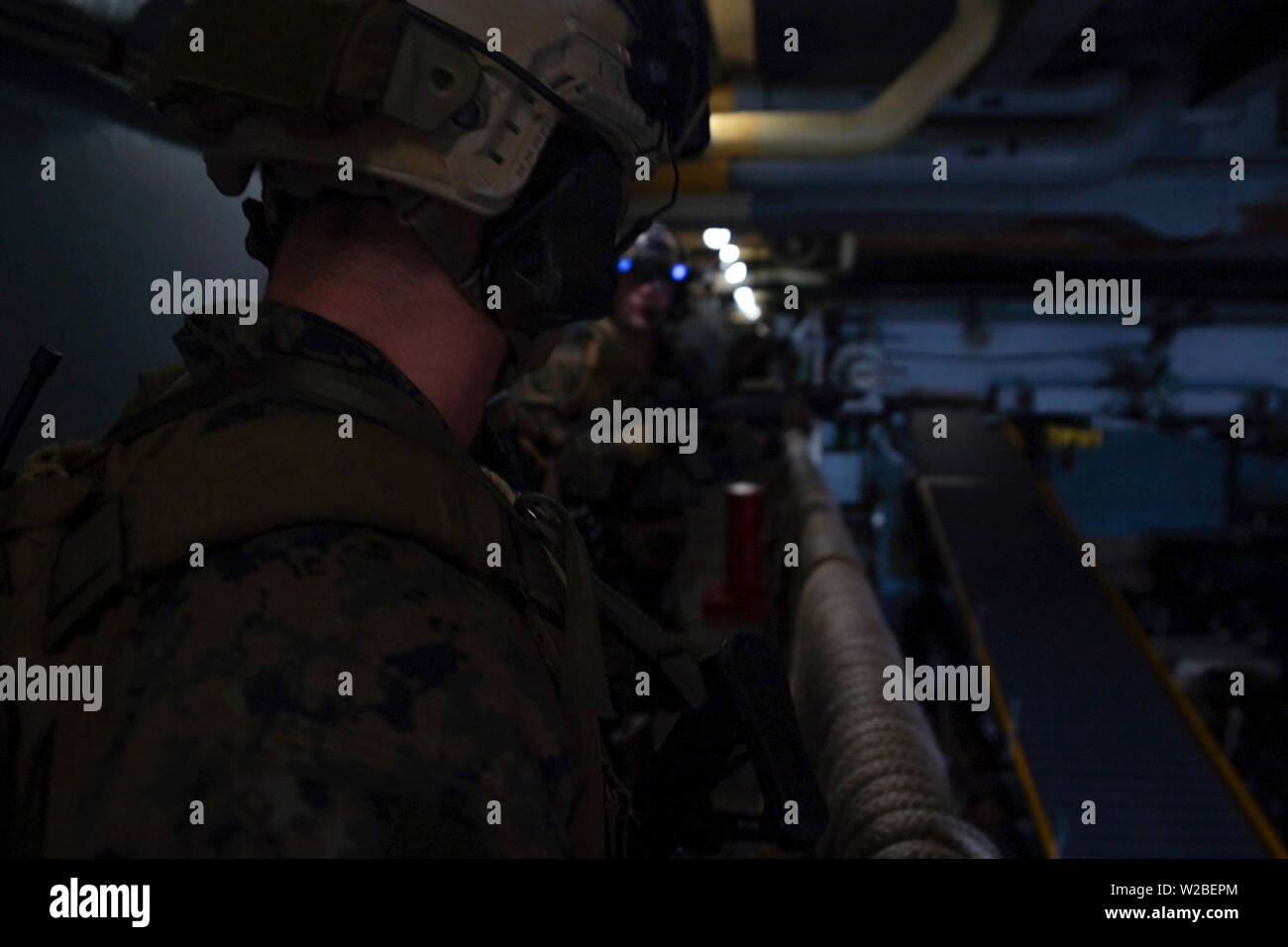 Force Reconnaissance Marines with Maritime Raid Force, 31st Marine Expeditionary Unit, move to the engine room while clearing the ship during a visit, board, search and seizure exercise aboard the amphibious dock landing ship USS Ashland (LSD 48), underway in the Coral Sea, June 29, 2019. Ashland, part of the Wasp Amphibious Ready Group, with embarked 31st MEU, is operating in the Indo-Pacific region to enhance interoperability with partners and serve as a ready-response force for any type of contingency, while simultaneously providing a flexible and lethal crisis response force ready to perfo Stock Photo
