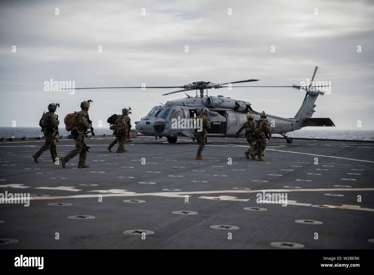 Force Reconnaissance Marines with Maritime Raid Force, 31st Marine Expeditionary Unit, board an MH-60S Sea Hawk during a visit, board, search and seizure exercise aboard the amphibious dock landing ship USS Ashland (LSD 48), underway in the Coral Sea, June 29, 2019. Ashland, part of the Wasp Amphibious Ready Group, with embarked 31st MEU, is operating in the Indo-Pacific region to enhance interoperability with partners and serve as a ready-response force for any type of contingency, while simultaneously providing a flexible and lethal crisis response force ready to perform a wide range of mili Stock Photo