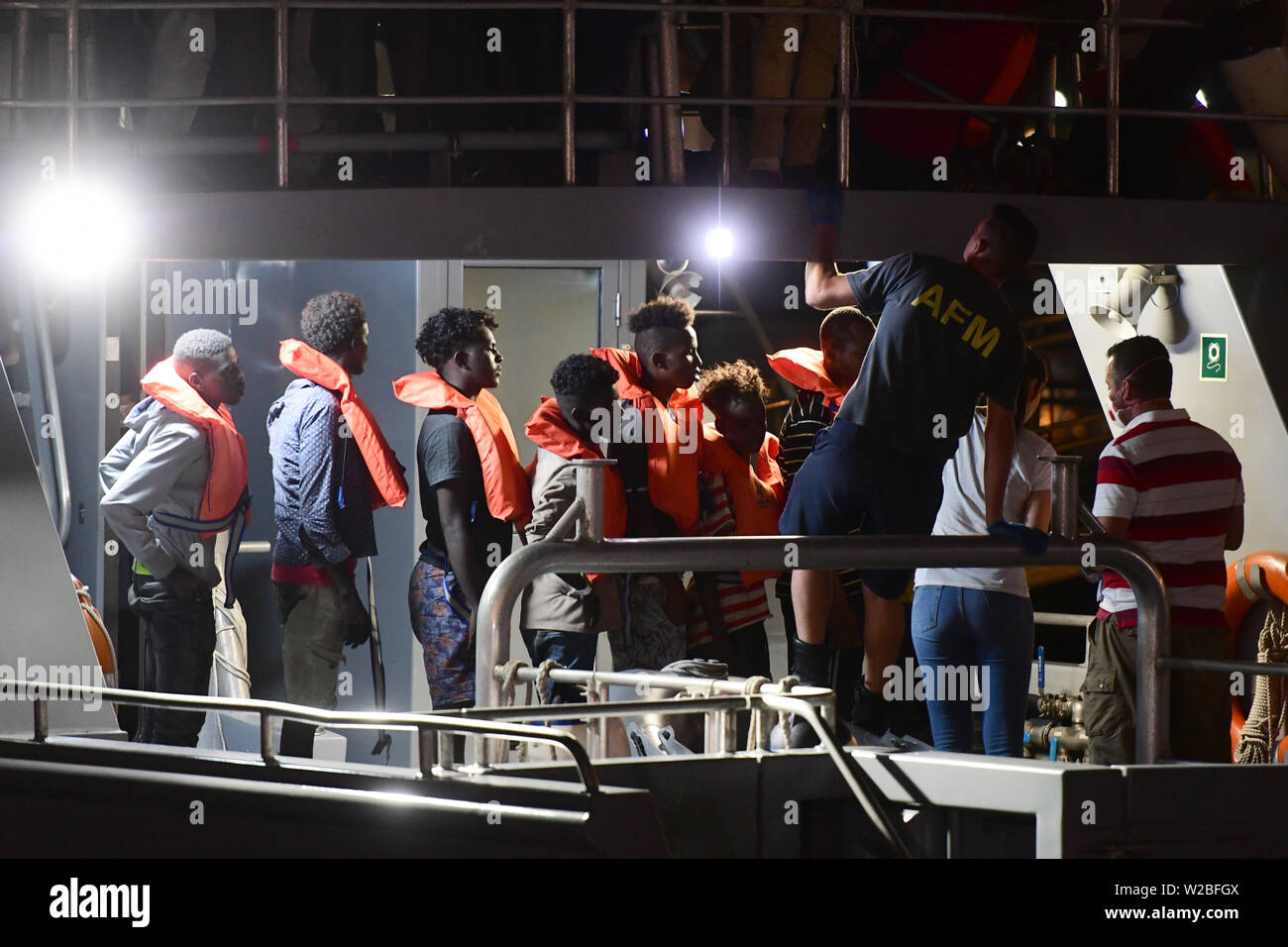 Floriana, Malta. 7th July, 2019. Migrants line up for disembarkation in Floriana, Malta, on July 7, 2019. Sixty-five migrants that were on board the vessel Alan Kurdi operated by a German NGO were transferred to an Armed Forces of Malta (AFM) patrol boat and disembarked at the army's Hay Wharf base late Sunday evening. Credit: Jonathan Borg/Xinhua/Alamy Live News Stock Photo