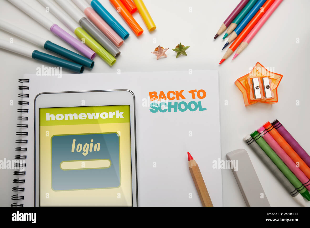 A students desk organized with school supplies for back to school that includes a tablet with login website for homework assignments and colored marke Stock Photo