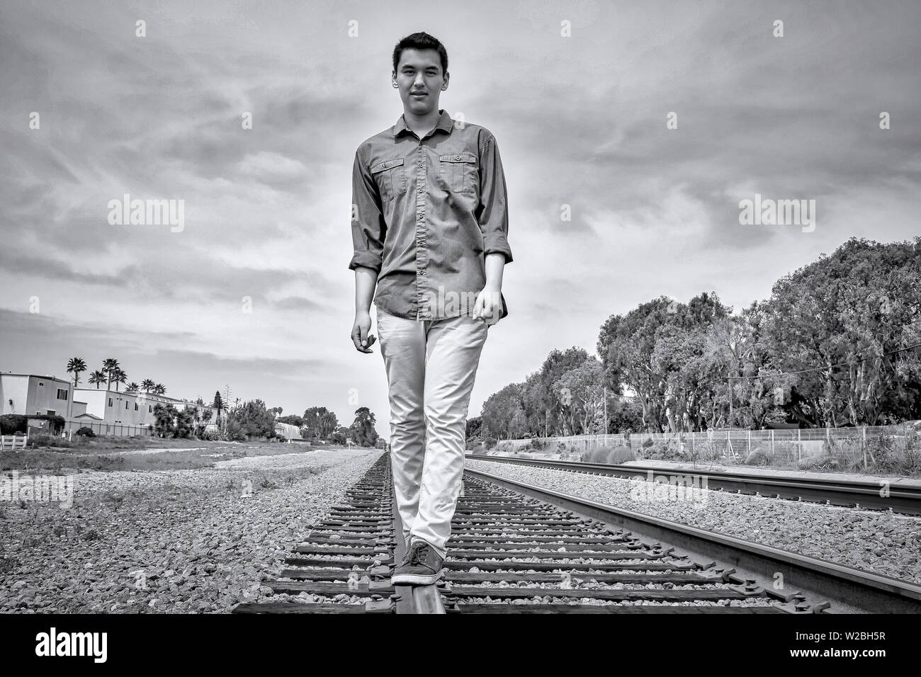 Young man walking on railway tracks in Carlsbad, California Stock Photo