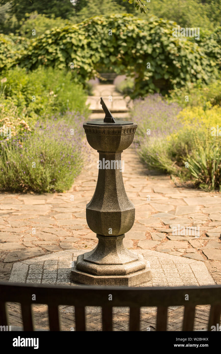 A sundial set in a formal garden of lavender lined, crazy paving paths. Stock Photo