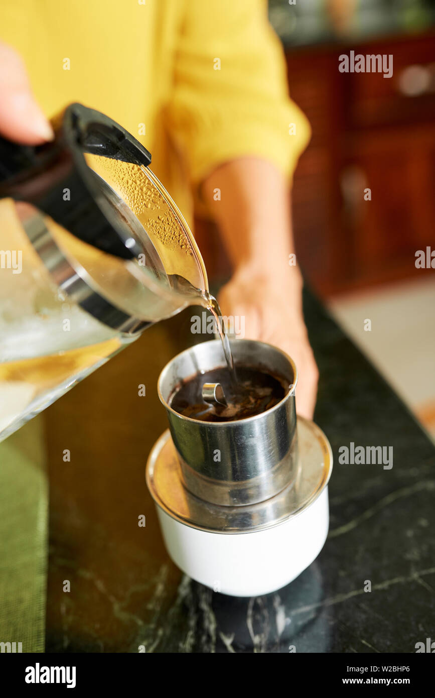 Person making delicious strong morning coffee in Vietnamese press Stock Photo