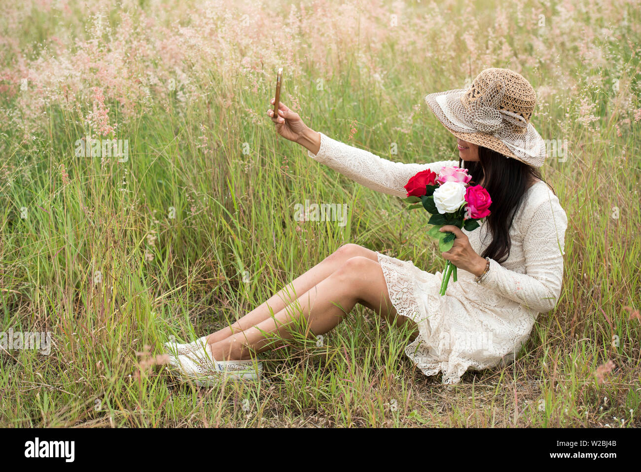 Portrait of a smiling young beautiful woman wear hat with a bouquet of ...