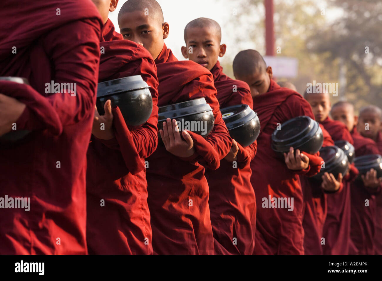 Monks collecting alms, Bagan, Myanmar (Burma) Stock Photo
