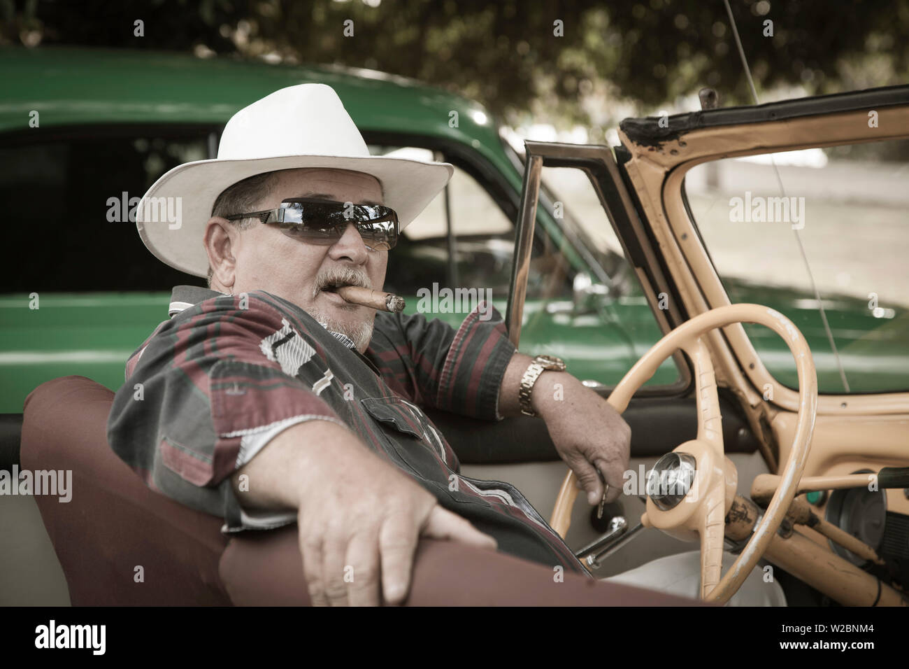 Cuban man in his Classic 50's Chevrolet, Havana, Cuba (MR) Stock Photo