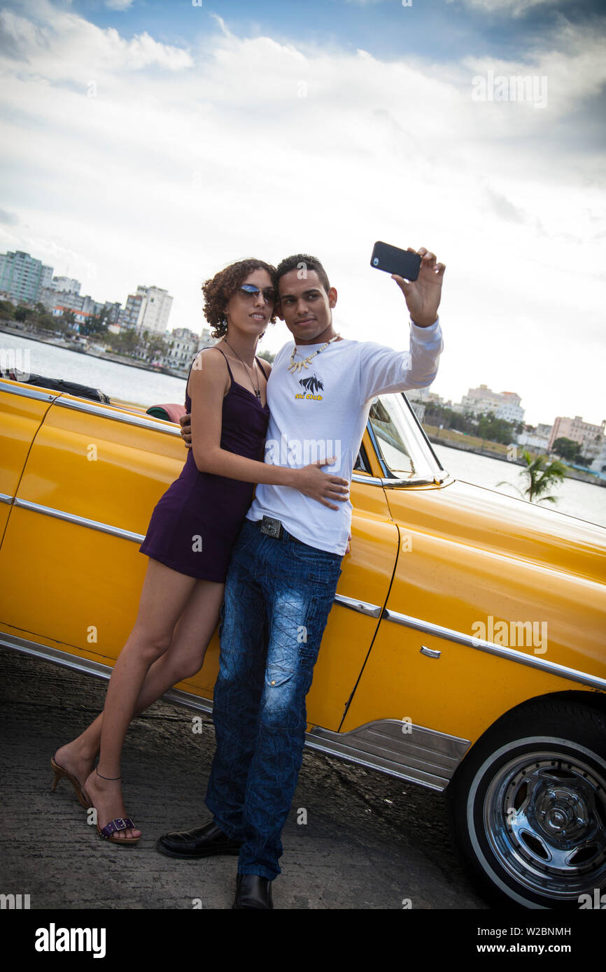 Young couple photographing themselves with a Classic 50's Chevrolet, Havana, Cuba (MR) Stock Photo