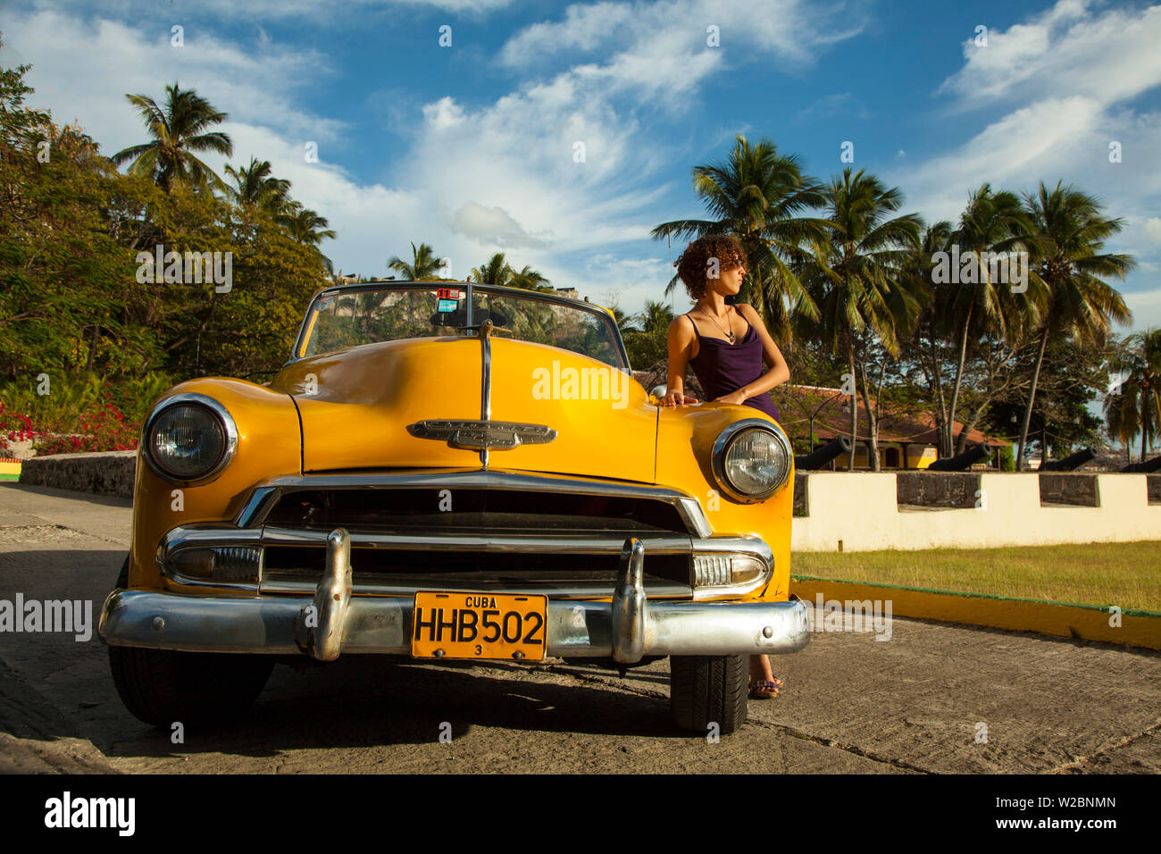 Young woman posing with a Classic 50's Chevrolet, Havana, Cuba (MR) Stock Photo