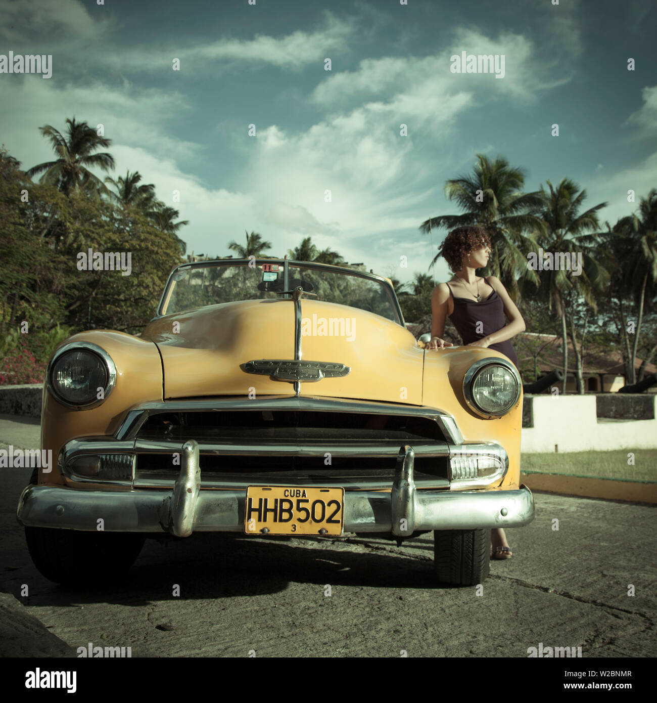 Young woman posing with a Classic 50's Chevrolet, Havana, Cuba (MR) Stock Photo