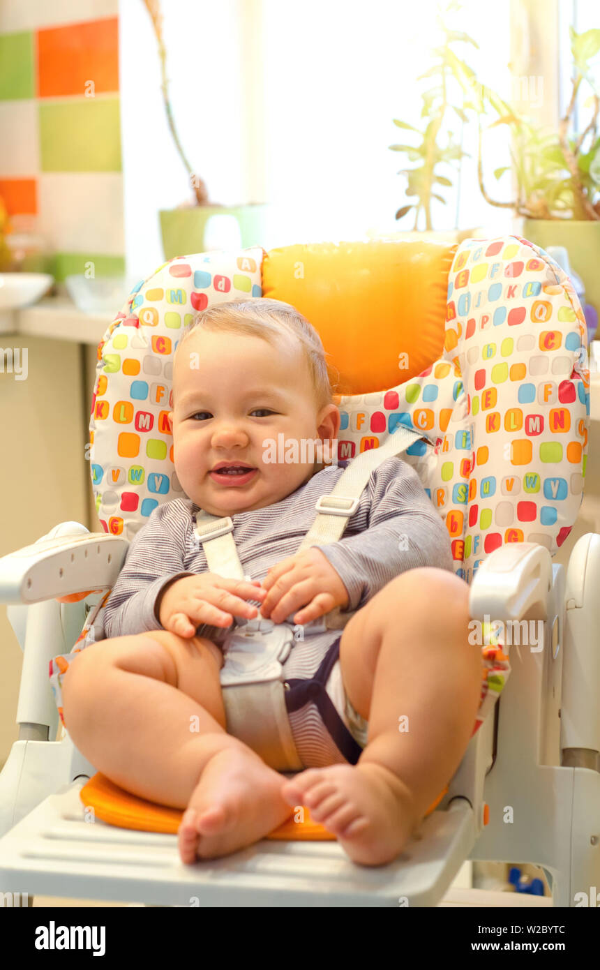 smiling baby boy sitting in the highchair Stock Photo