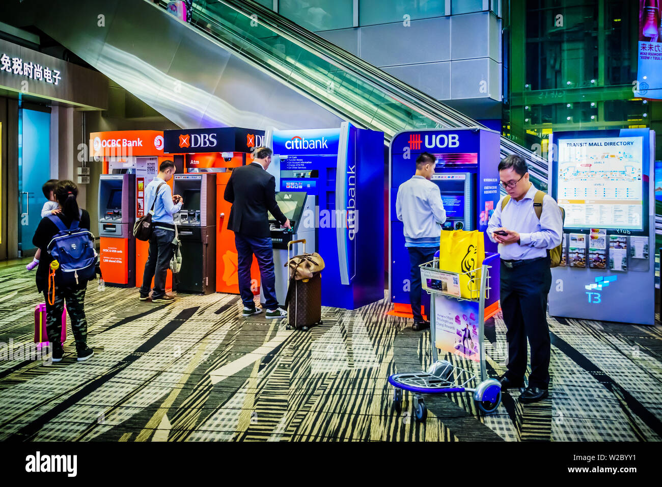 Singapore - May 8, 2019: Travellers carry out banking services via ATM ...
