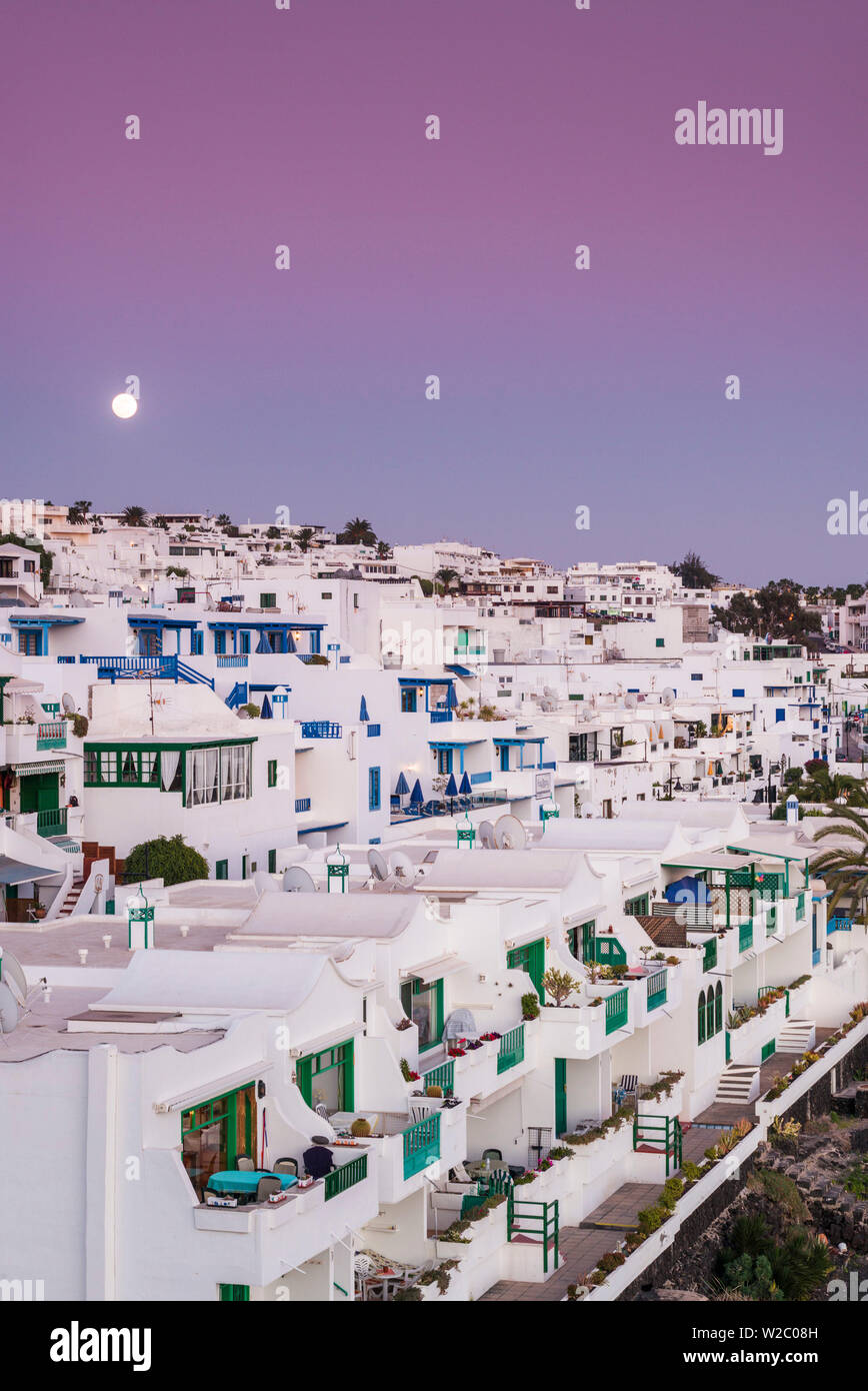 Spain, Canary Islands, Lanzarote, Puerto del Carmen, seaside houses and moonrise, dusk Stock Photo