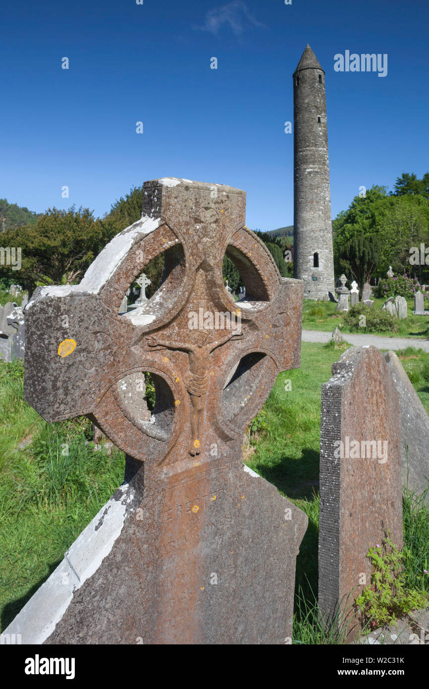 Ireland, County Wicklow, Glendalough, ancient monastic settlement started by St. Kevin, Celtic cross and Round Tower Stock Photo