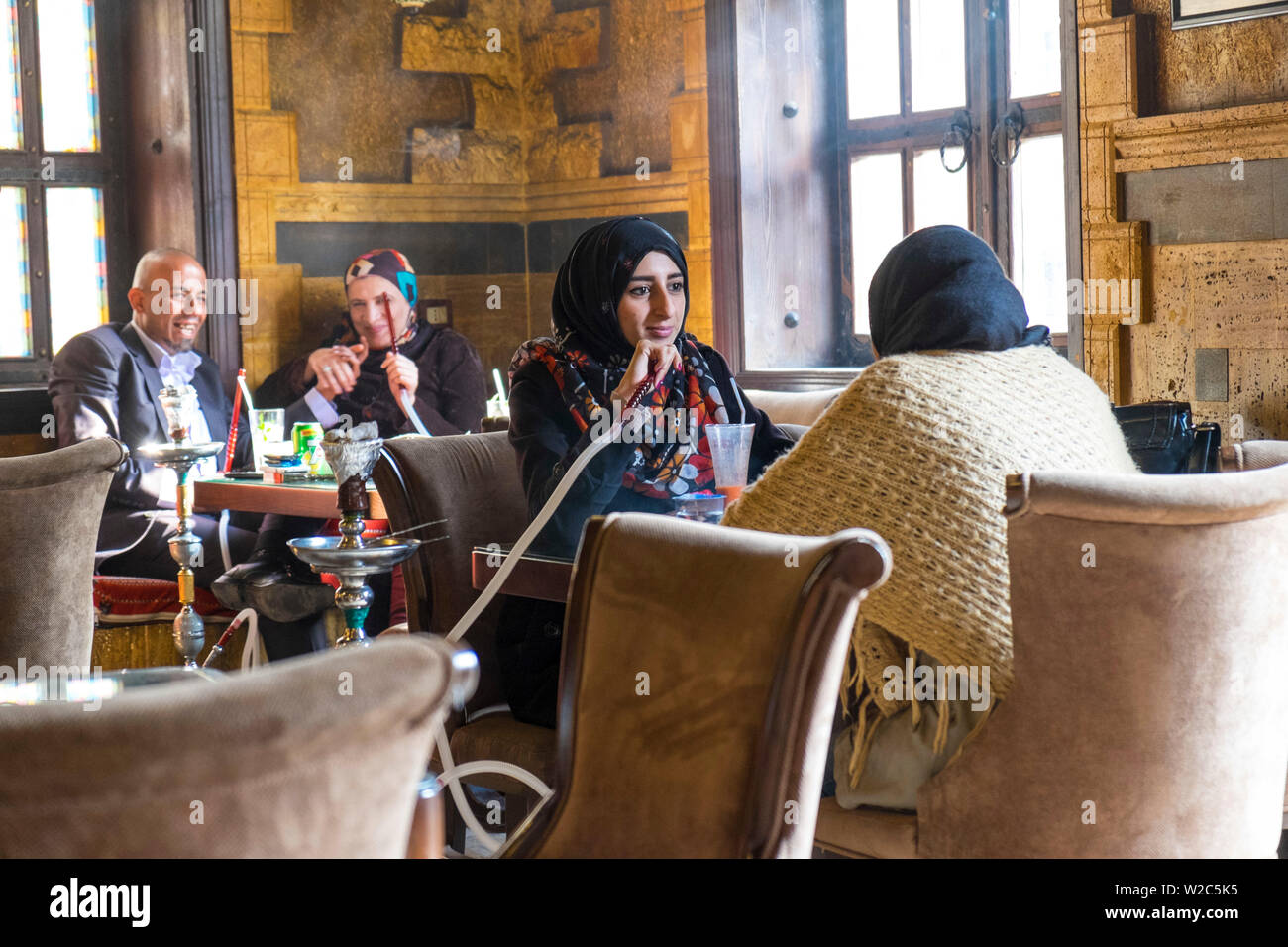 Woman smoking shisha pipe (hookah or water pipe) in cafe, downtown Amman, Jordan Stock Photo