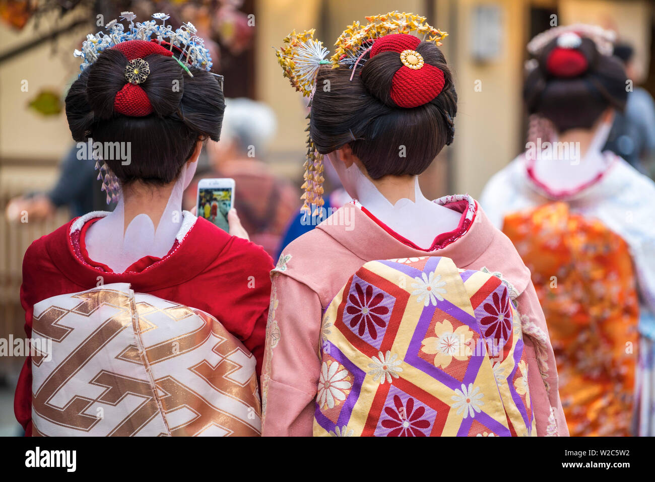 Women dressed in traditional geisha dress & mobile phone camera, Kyoto, Japan Stock Photo