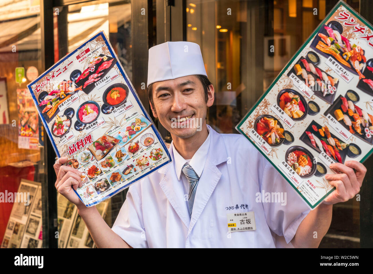 Waiter enticing customers into Sushi restaurant, Tokyo, Japan Stock Photo