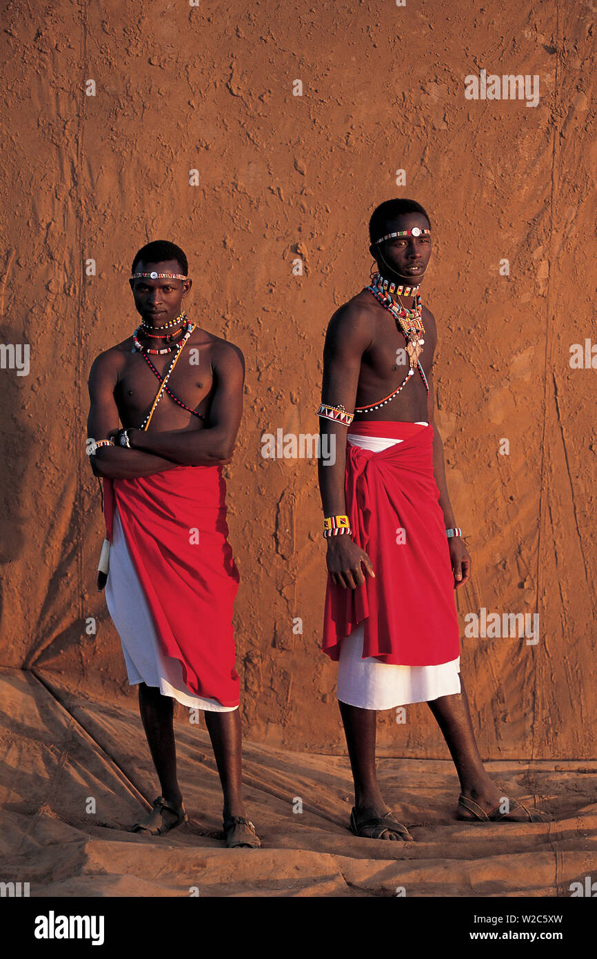 Samburu warriors, infront of muddy backdrop at Sunset, Laikipia Kenya Stock Photo