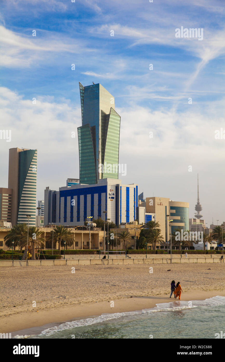 Kuwait, Kuwait City, Sharq, Women walking along a city beach on Arabian Gulf Street with city center buildings Stock Photo