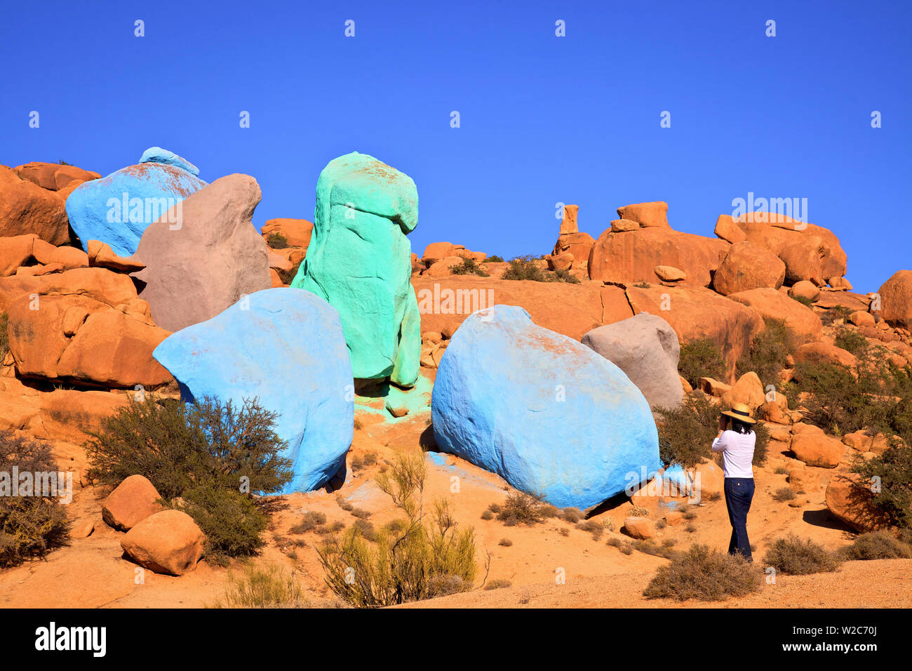 Tourist Taking Photographs Of Painted Rocks By Belgian Artist Jean Verame, Tafraoute, Morocco, North Africa (MR) Stock Photo