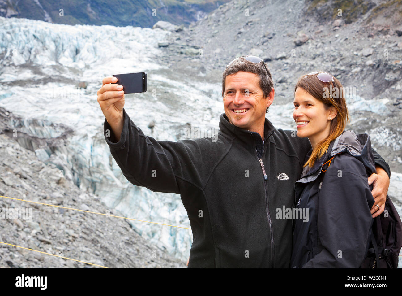 Couple taking self portrait, Fox Glacier, West Coast, South Island, New Zealand Stock Photo